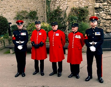 A picture of three Chelsea veterans flanked by two active Military Policemen in Parade Dress